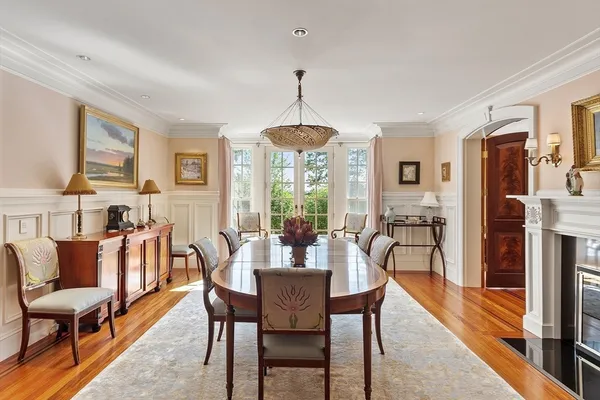 a dining room with furniture a chandelier and wooden floor