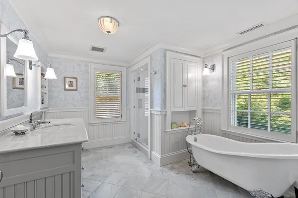 a bedroom with a bed a bookshelf and a large window