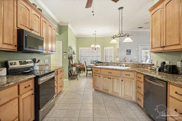 a large kitchen with stainless steel appliances granite countertop a stove a sink dishwasher and a microwave oven with white cabinets