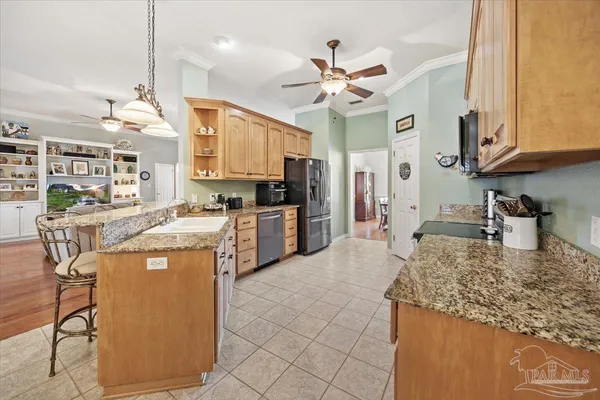a kitchen with stainless steel appliances granite countertop a sink a stove and a refrigerator