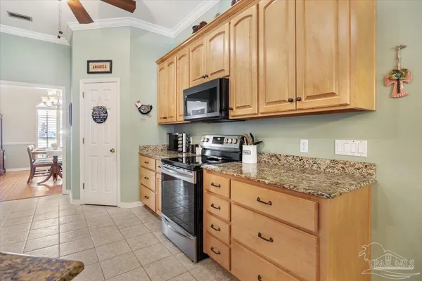 a kitchen with stainless steel appliances granite countertop a stove a sink and a microwave