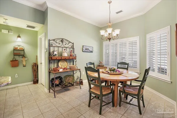 a view of a dining room with furniture and a chandelier