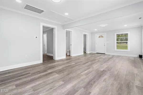 an empty room with wooden floor and windows