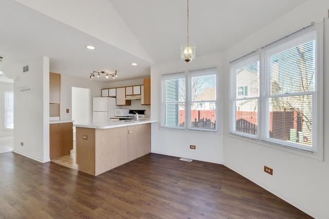 1822 Olde Mill Road Plainfield, IL 60586 - Photo 18 of 29 a large white kitchen with wooden floors and white walls