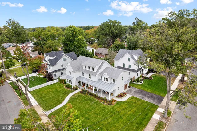 an aerial view of residential houses with outdoor space and trees