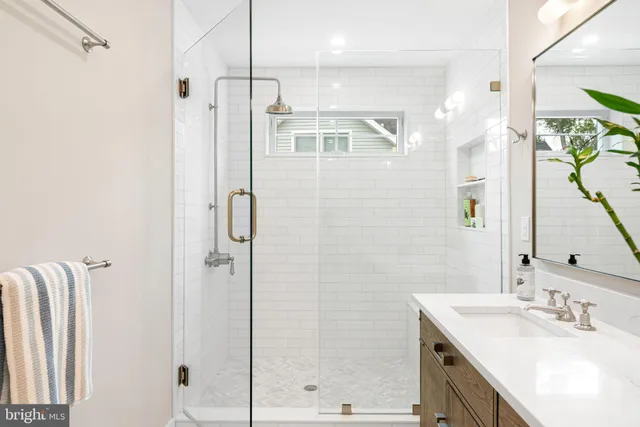 a view of a hallway to a livingroom with wooden floor and furniture