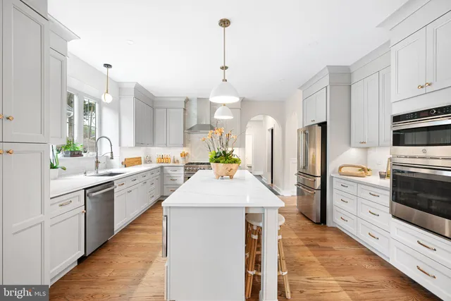 a kitchen with stainless steel appliances kitchen island granite countertop a stove a sink and a refrigerator