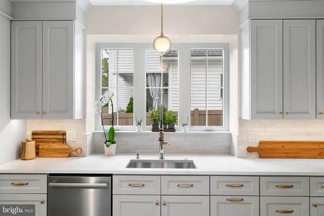 a kitchen with stainless steel appliances a refrigerator a stove and white cabinets