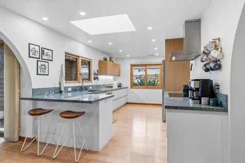 a kitchen with granite countertop kitchen island stainless steel appliances a sink and a counter top space