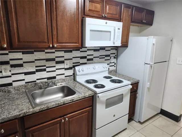 a kitchen with a sink stove and refrigerator