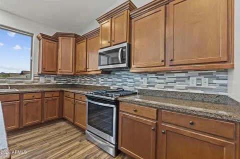 a kitchen with stainless steel appliances granite countertop a sink stove and microwave