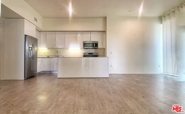 a kitchen with granite countertop a refrigerator and a sink