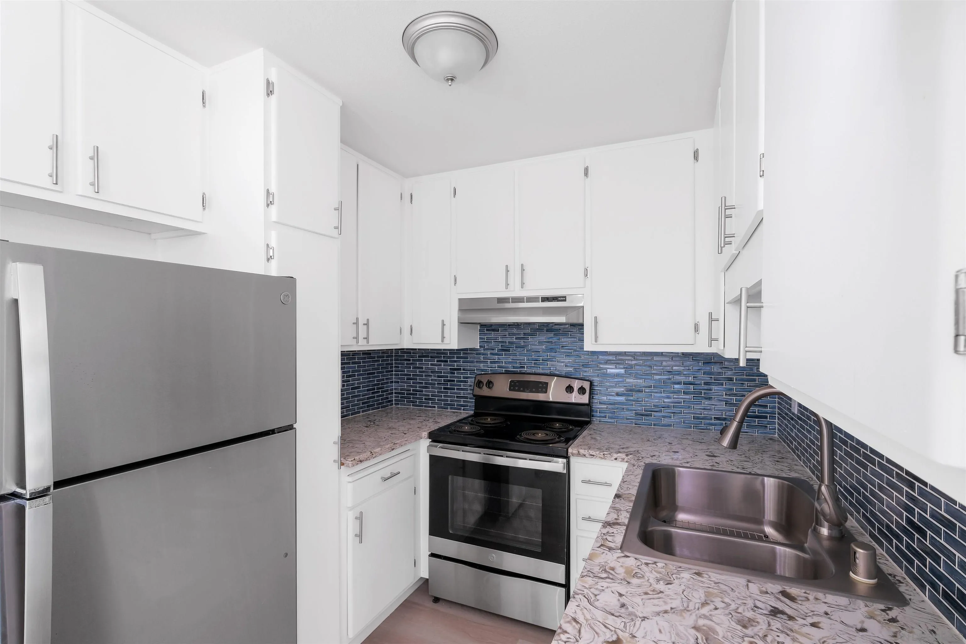 3827 Conrad Drive Spring Valley, CA 91977 - Photo 3 of 9 a kitchen with a refrigerator sink and cabinets