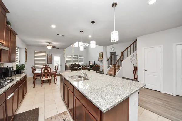 a kitchen with kitchen island granite countertop a sink stove and cabinets