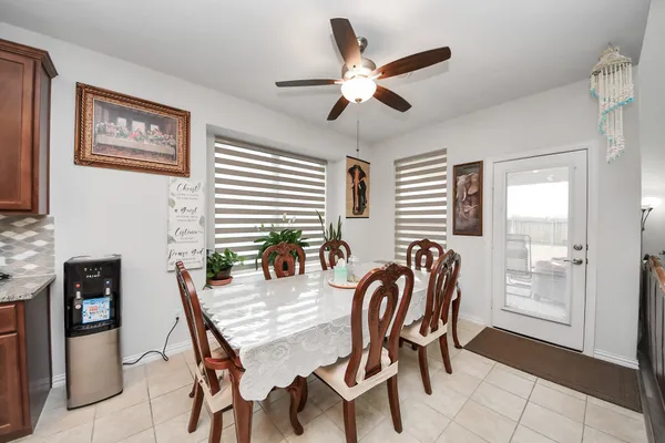 a dining room with kitchen island stainless steel appliances furniture a chandelier and a dining table