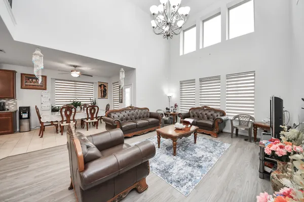 a living room with furniture a chandelier and a rug