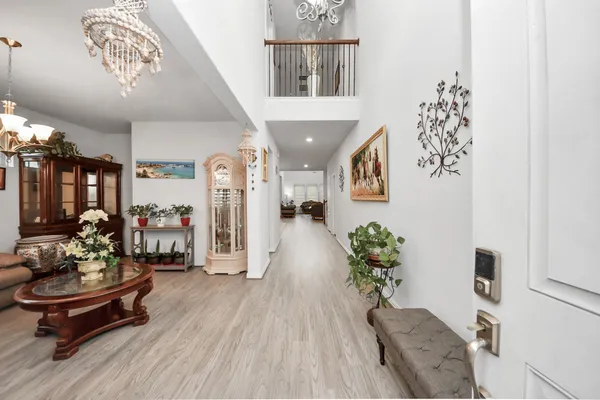 a living room with furniture a dining table and a chandelier