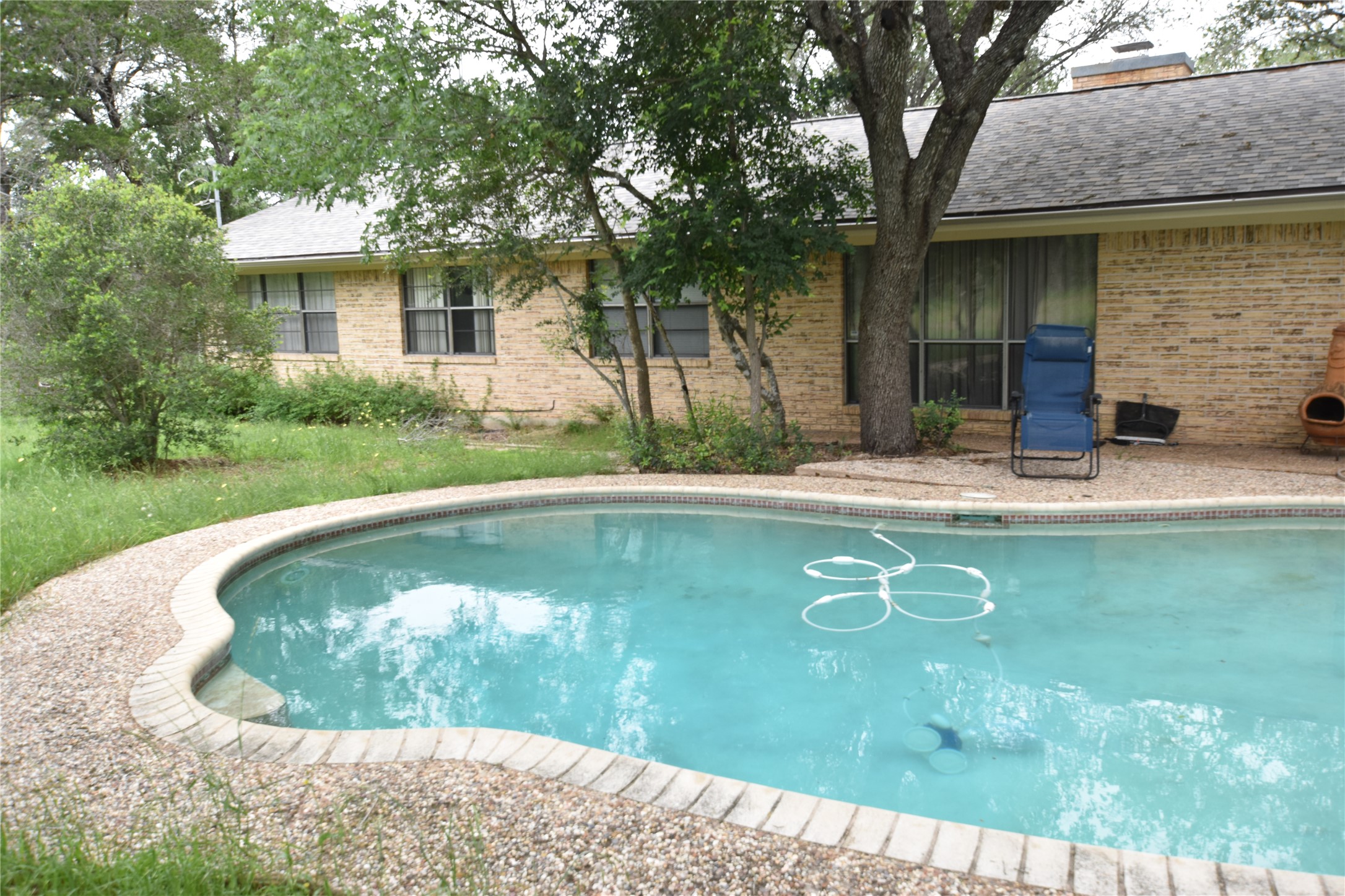 687 Fm 812 Road Red Rock, TX 78662 - Photo 23 of 40 Freeform swimming pool featuring a brick coping.
