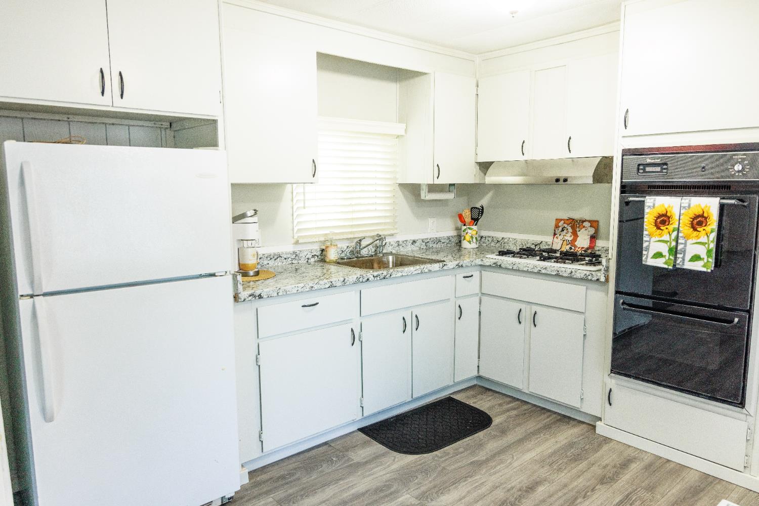 10251 Combie Road, Unit 13 Auburn, CA 95602 - Photo 4 of 16 a kitchen with a refrigerator sink and cabinets