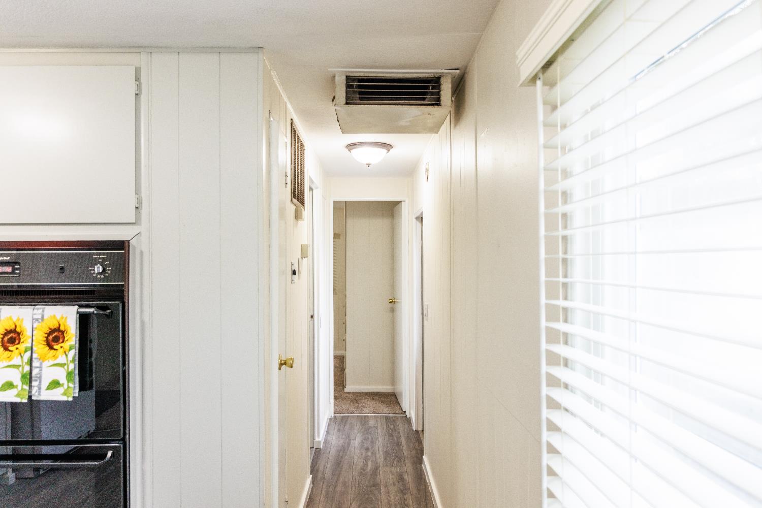 10251 Combie Road, Unit 13 Auburn, CA 95602 - Photo 5 of 16 a view of a hallway with wooden floor and a bathroom