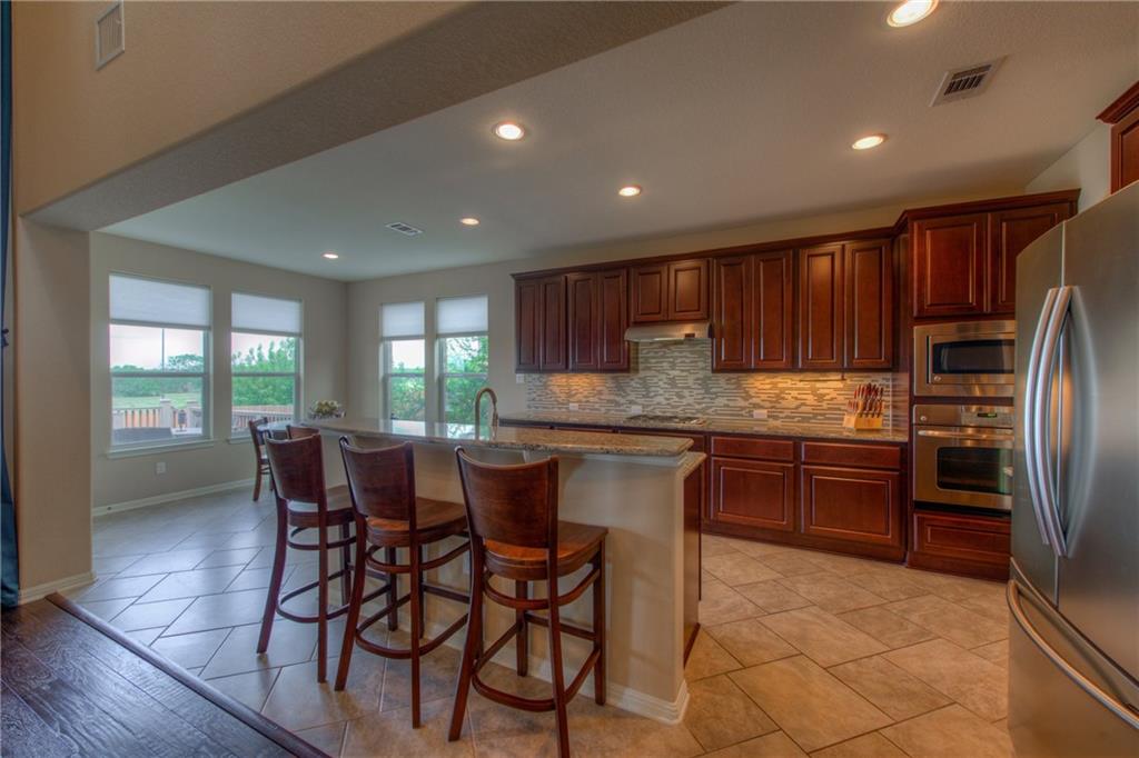1511 Rimstone Drive Cedar Park, TX 78613 - Photo 11 of 40 a kitchen with stainless steel appliances granite countertop wooden cabinets a stove top oven a sink and dishwasher
