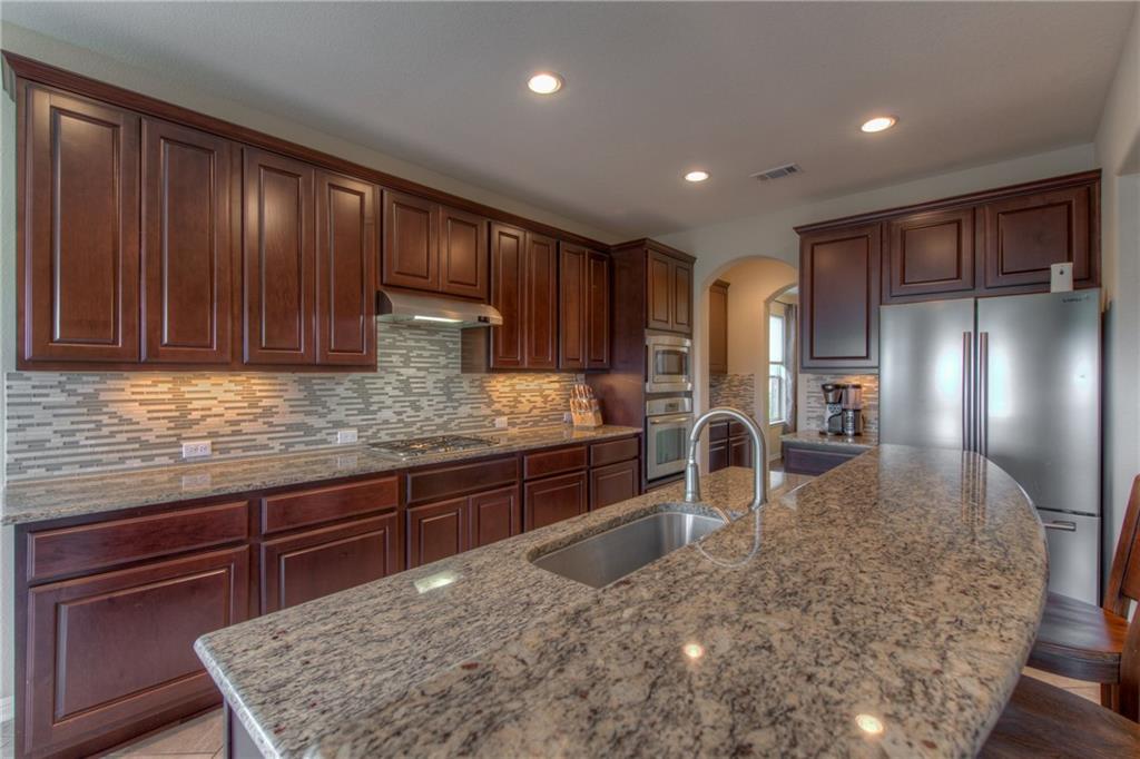 1511 Rimstone Drive Cedar Park, TX 78613 - Photo 13 of 40 a kitchen with stainless steel appliances granite countertop wooden cabinets a oven and granite counter tops with a large window