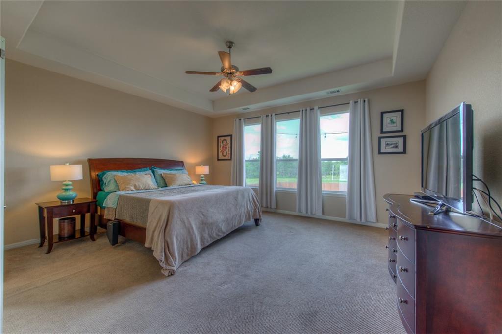 1511 Rimstone Drive Cedar Park, TX 78613 - Photo 18 of 40 a bedroom with a bed flat screen tv and a large window