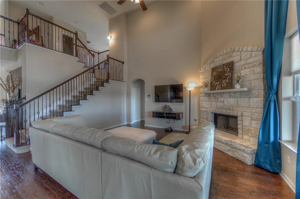 1511 Rimstone Drive Cedar Park, TX 78613 - Photo 9 of 40 a living room with furniture a fireplace and a flat screen tv