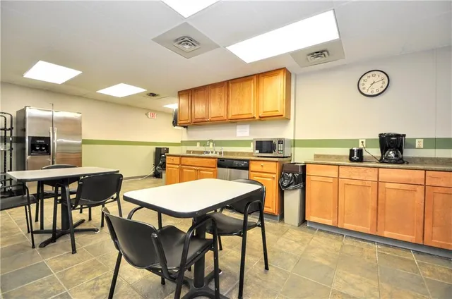 a kitchen with a table chairs and a refrigerator