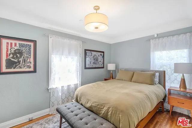 a bedroom with a bed and a painting on the wall