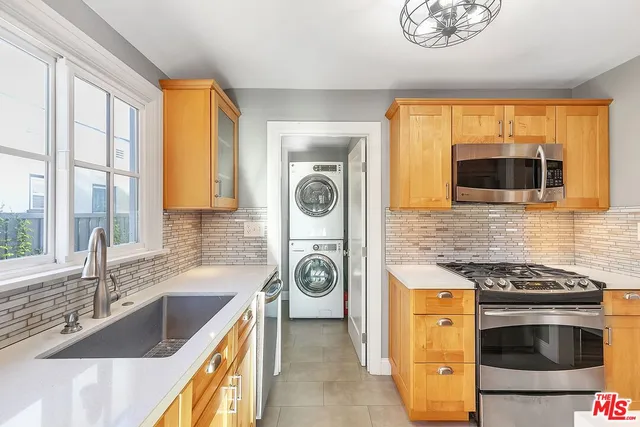 a kitchen with stainless steel appliances granite countertop a sink and a granite counter tops with a large window