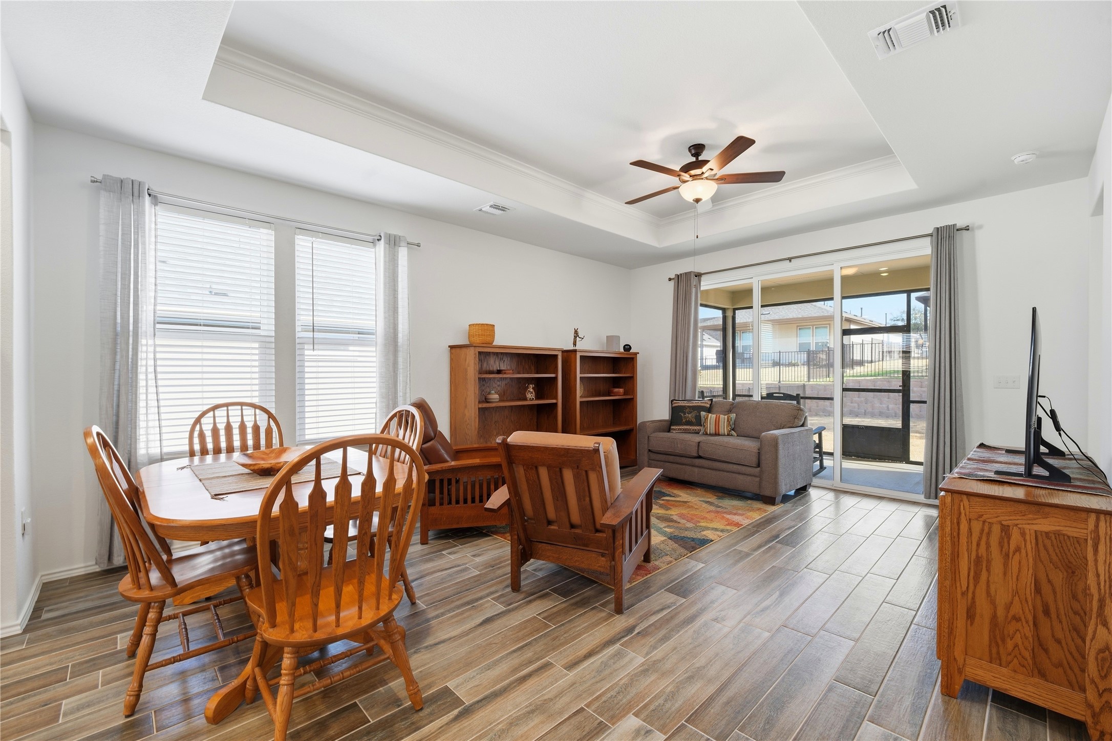 122 Clay Hl Street Georgetown, TX 78633 - Photo 11 of 31 Dining space featuring ceiling fan, wood finish floors, a tray ceiling, and ornamental molding