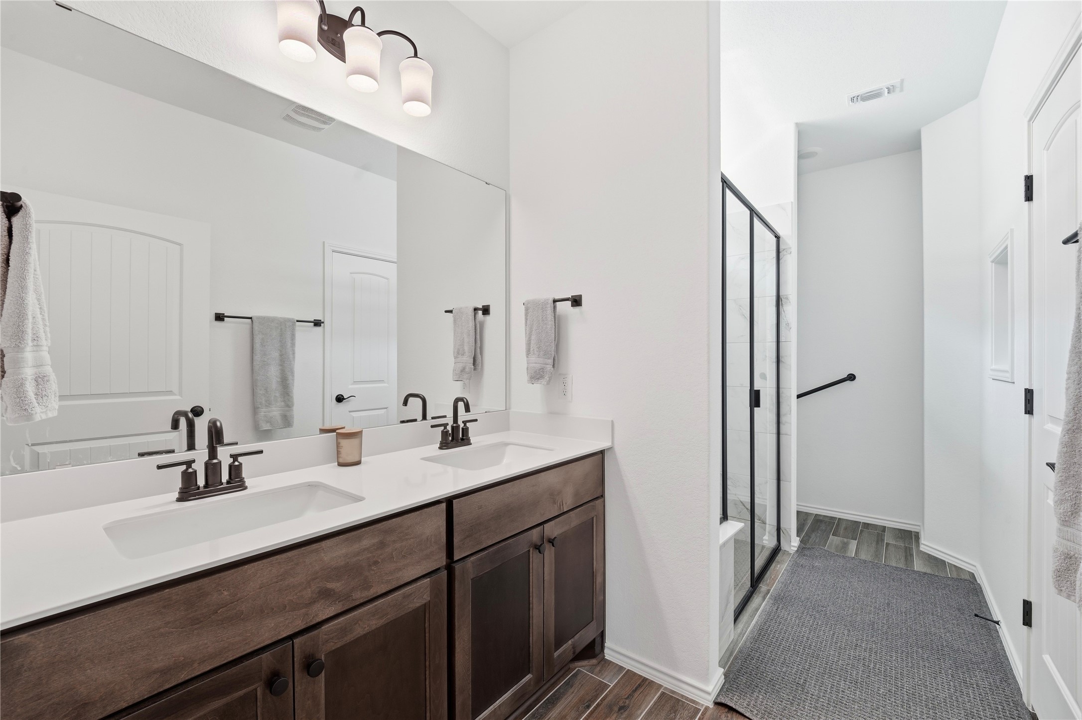 122 Clay Hl Street Georgetown, TX 78633 - Photo 17 of 31 Bathroom featuring a shower stall, double vanity, and dark wood-type flooring