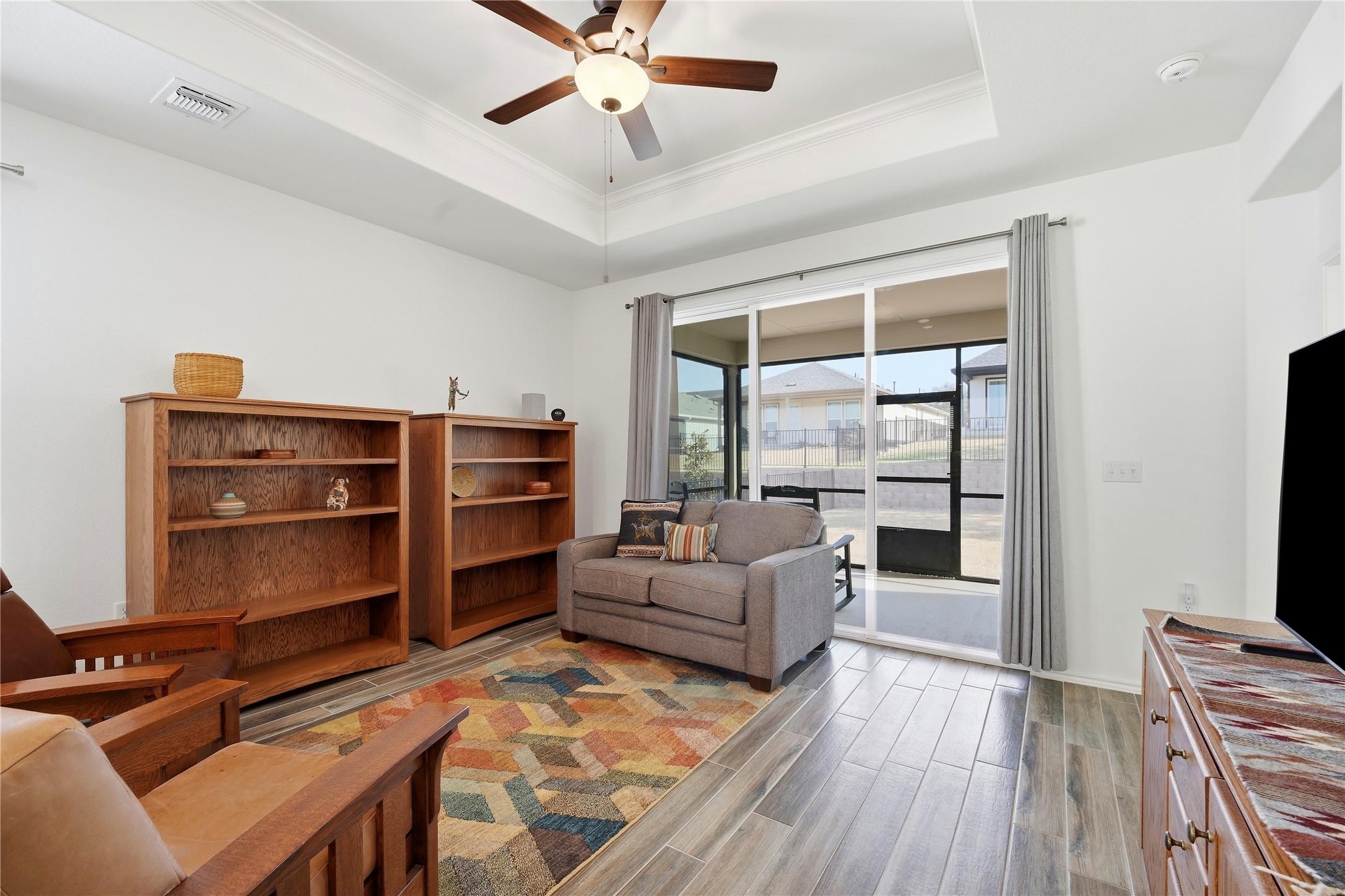 122 Clay Hl Street Georgetown, TX 78633 - Photo 2 of 31 Living area with wood tiled floors, a ceiling fan, crown molding, and a tray ceiling