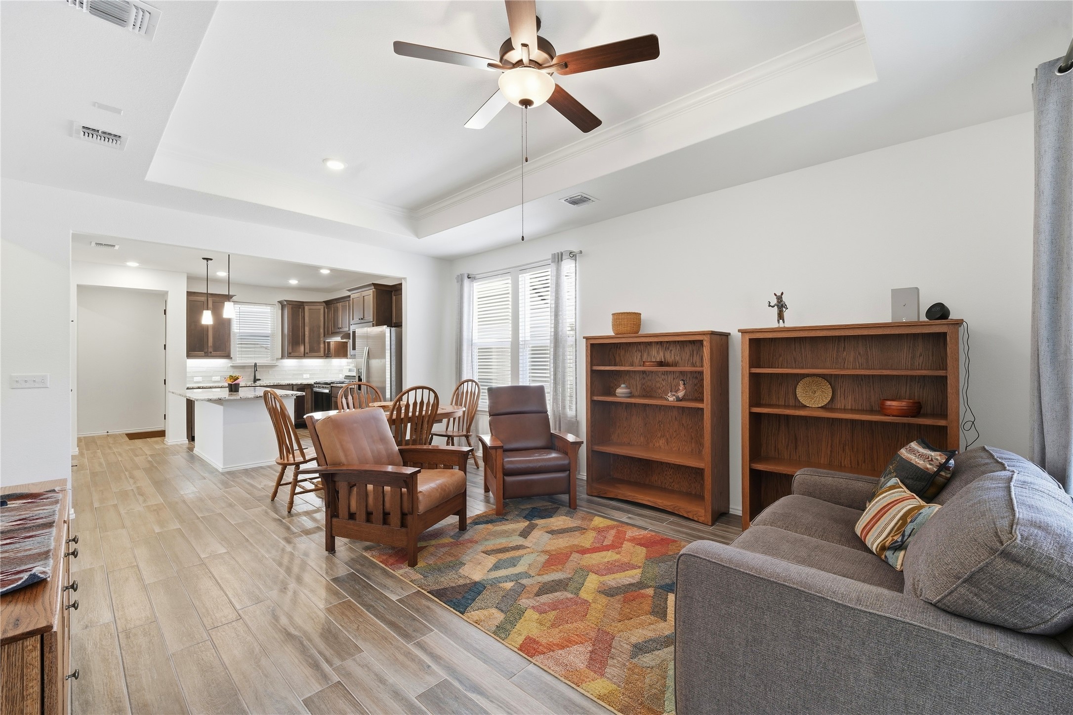 122 Clay Hl Street Georgetown, TX 78633 - Photo 3 of 31 Living area featuring light wood finished floors, a raised ceiling, a ceiling fan, and recessed lighting