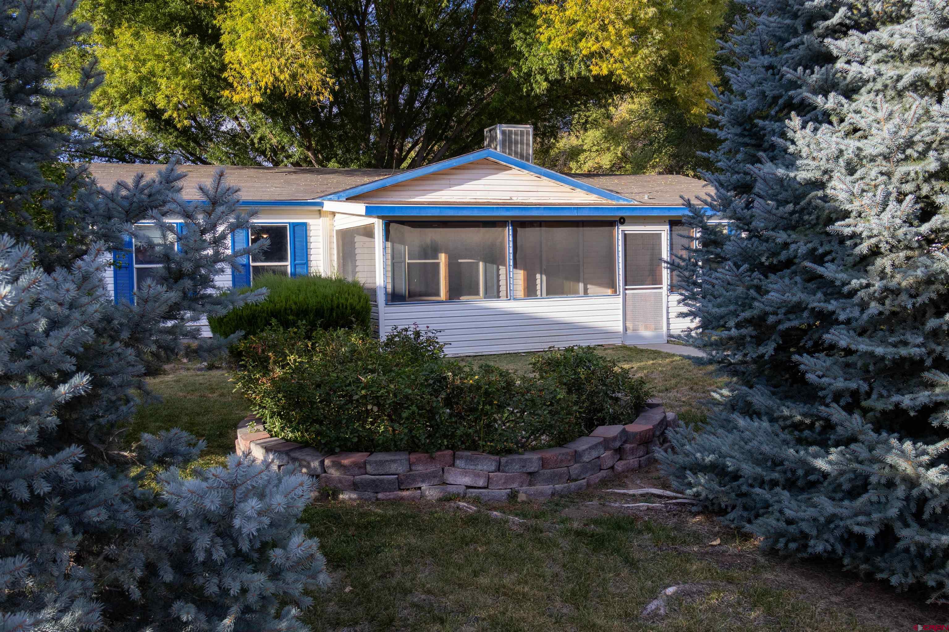 a front view of a house with a yard and green space