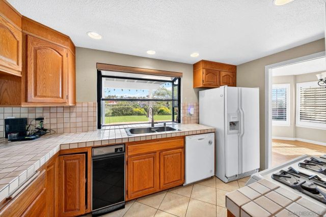 a view of an empty room with window and chandelier fan