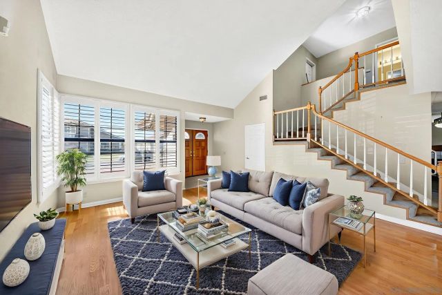 a living room with furniture and a table with wooden floor