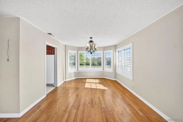 a view of hallway with wooden floor and chandelier