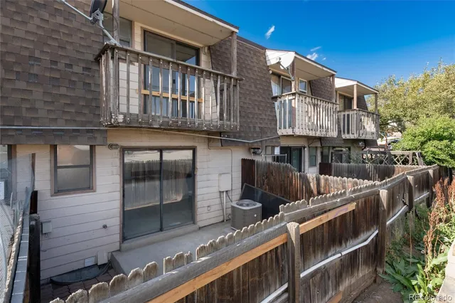 a view of a house with roof and wooden fence