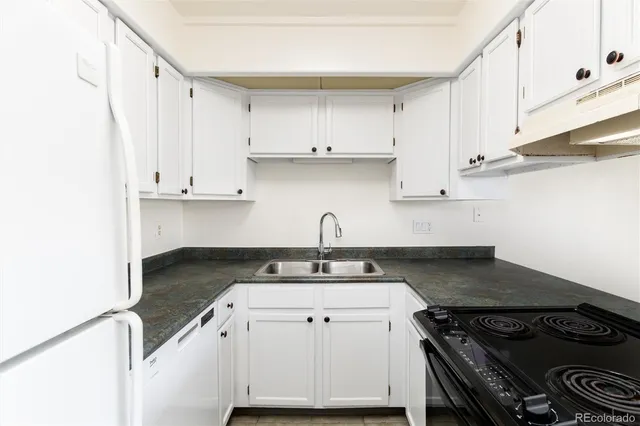 a kitchen with granite countertop a stove sink and cabinets