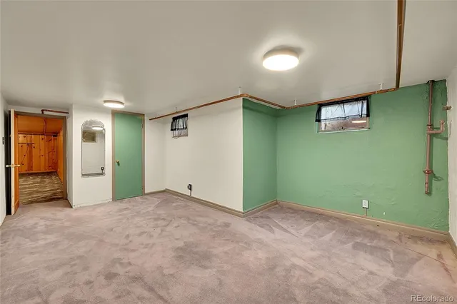 a view of an empty room with closet and a window
