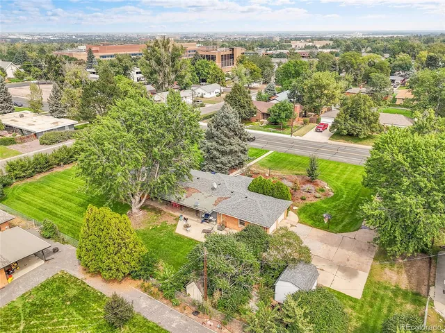 an aerial view of residential houses with outdoor space and trees