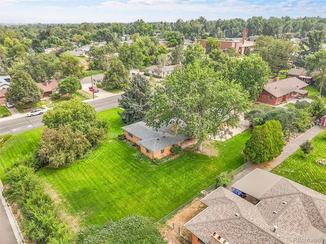an aerial view of residential houses with outdoor space and trees
