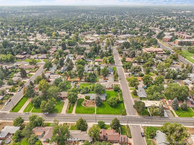 an aerial view of residential houses with outdoor space and trees