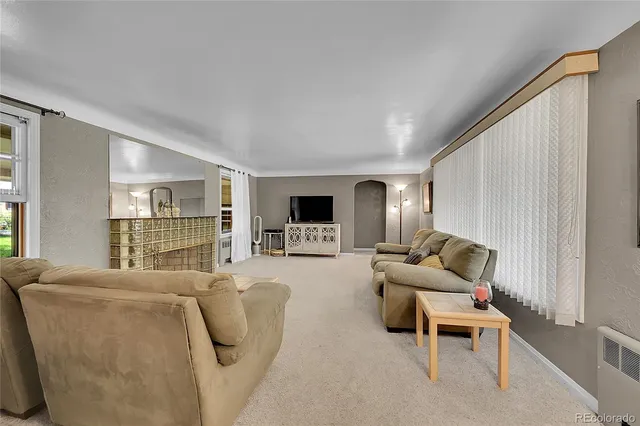 a living room with furniture a flat screen tv and a large window