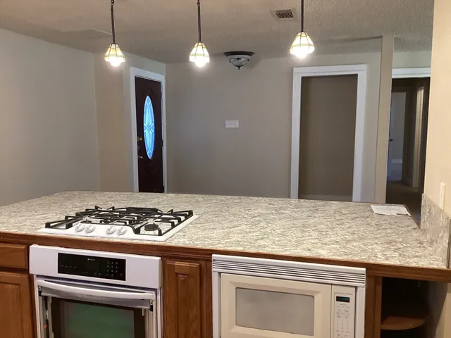 a kitchen with a stove and a wooden floor