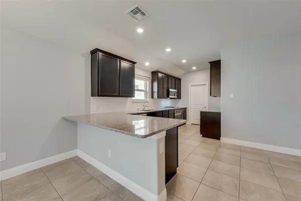 a kitchen with stainless steel appliances granite countertop a sink and a stove