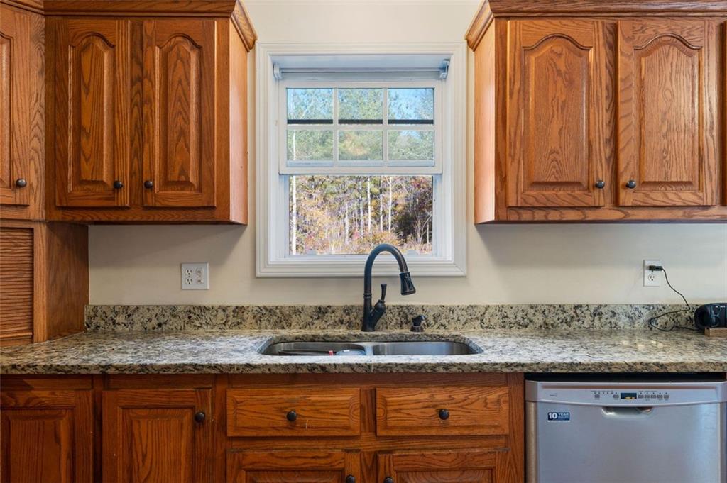 577 Everett Springs Road Southwest Calhoun, GA 30701 - Photo 12 of 34 a kitchen with granite countertop a sink a stove and cabinets