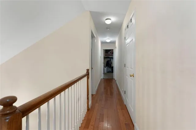 a view of a hallway with wooden floor and staircase
